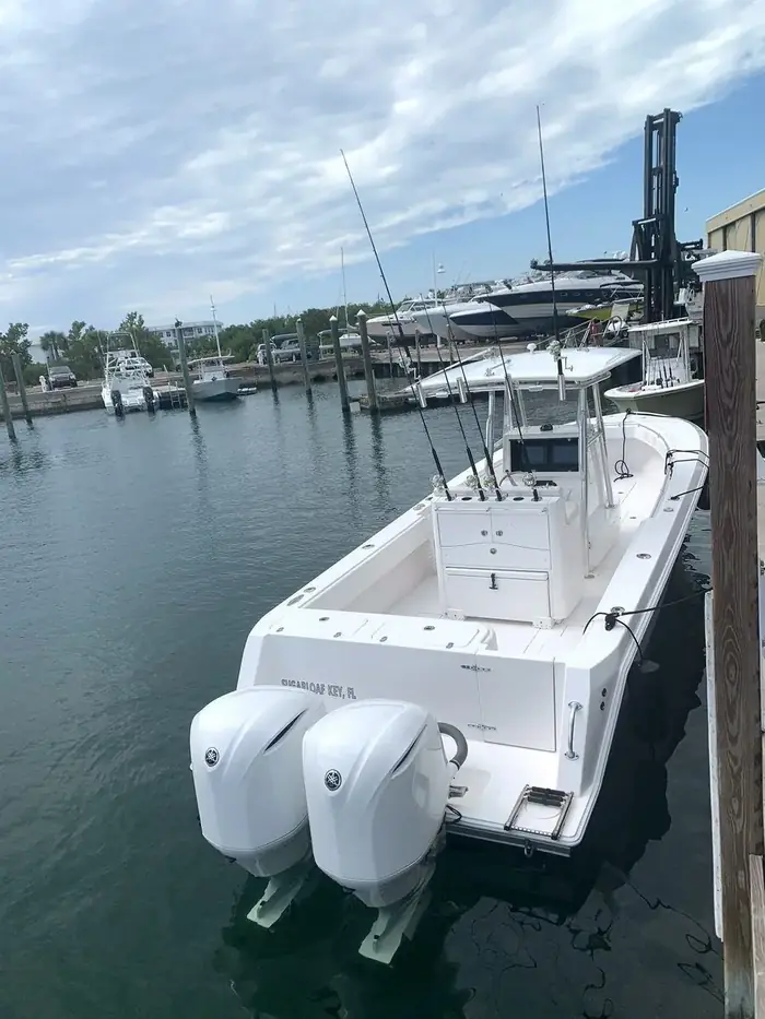 Blue Cowboy – dockside stern view with twin Yamaha outboards and rods rigged in the rocket launcher, Key West FL