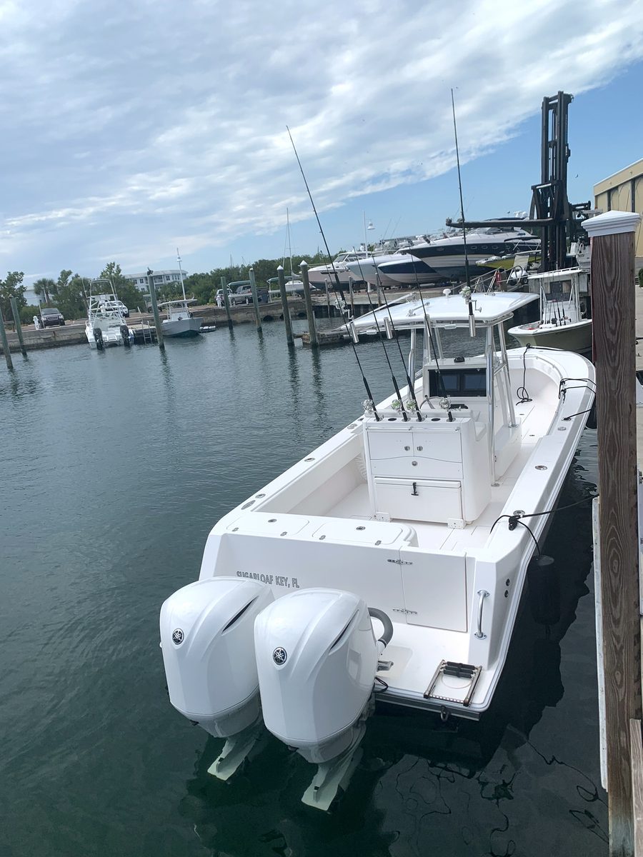 Blue Cowboy – dockside stern view with twin Yamaha outboards and rods rigged in the rocket launcher, Key West FL