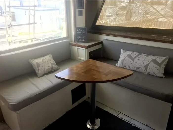 Comfortable cabin seating with wood table aboard the Cowgirl, Key West