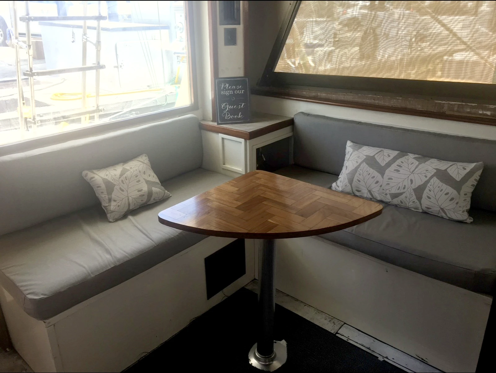 Comfortable cabin seating with wood table aboard the Cowgirl, Key West