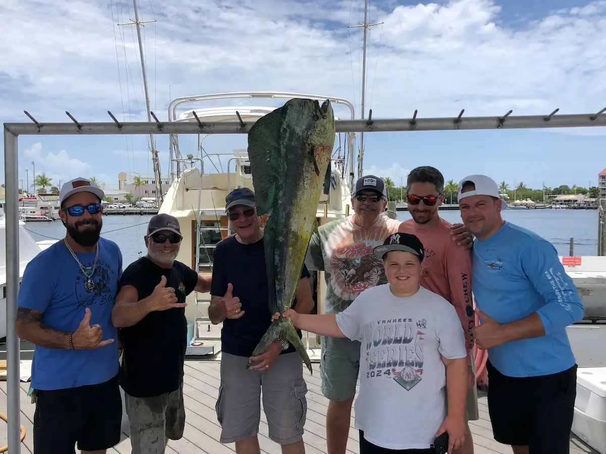 Group celebrating with a big mahi-mahi at the dock