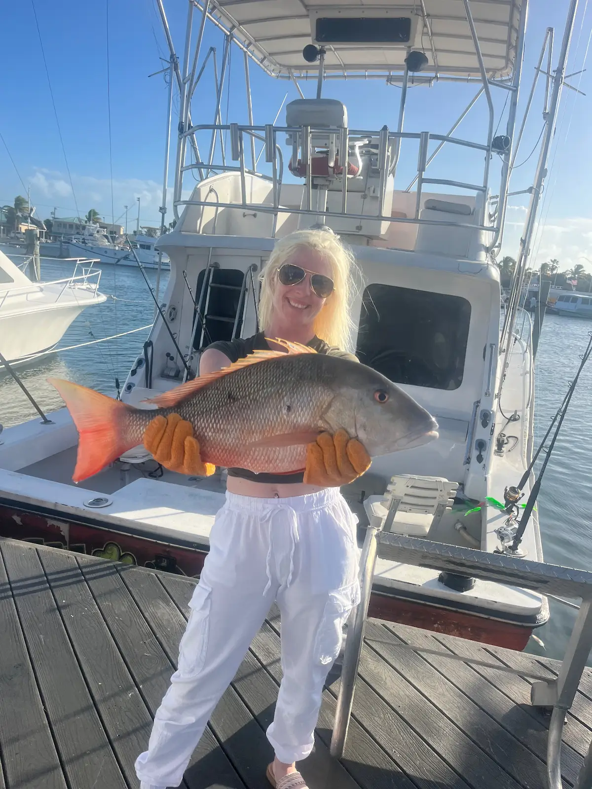 Happy angler with a beautiful mutton snapper at the dock
