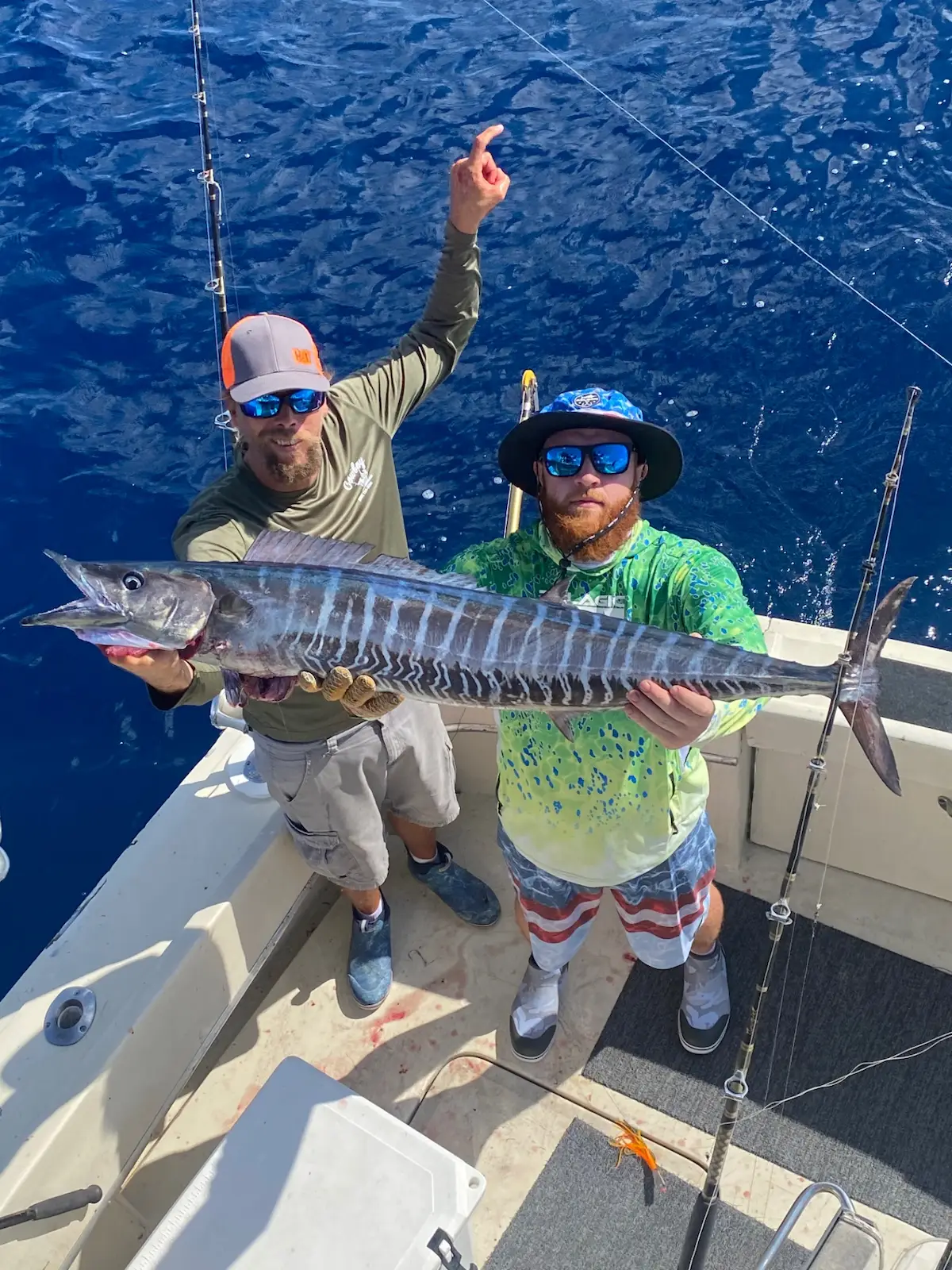 Two anglers celebrating a massive wahoo