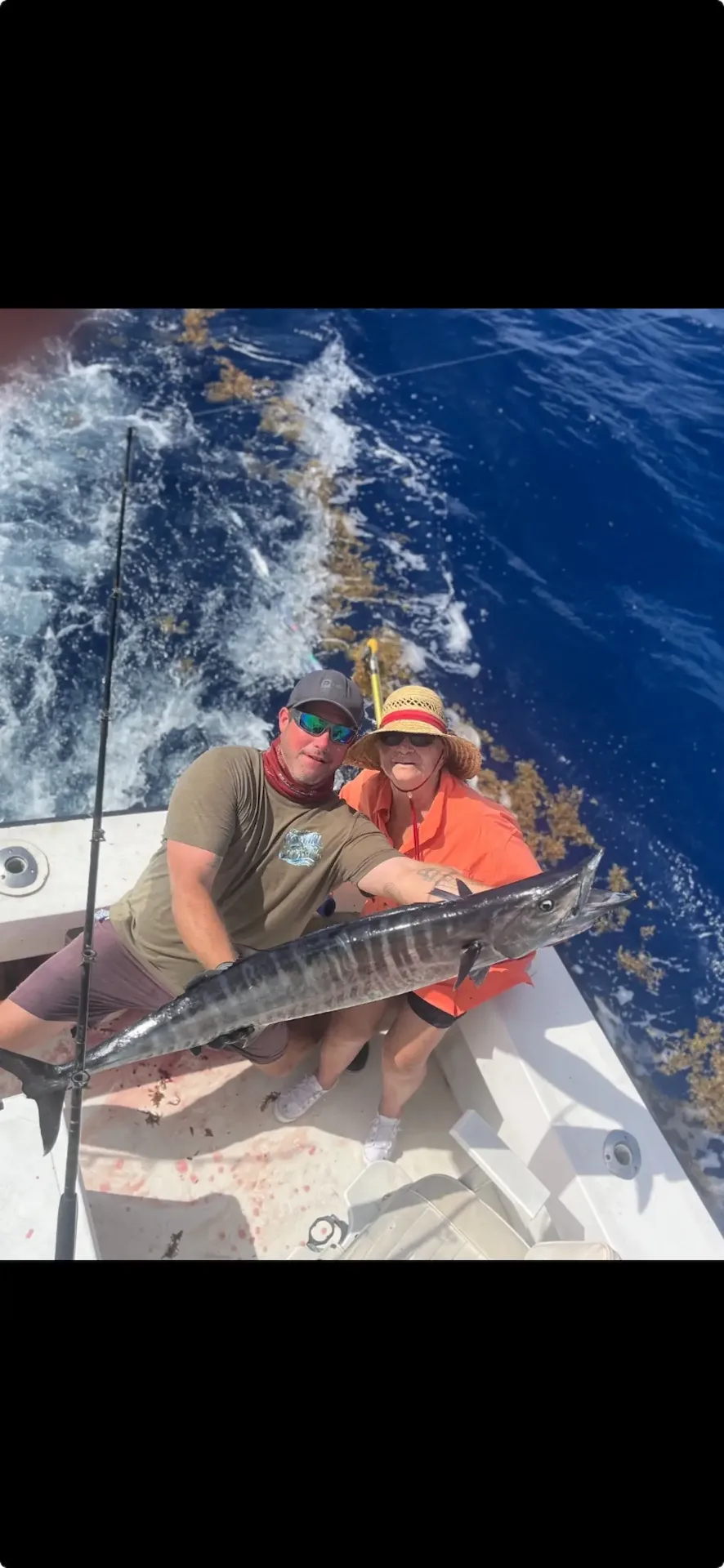 Two anglers with wahoo catch in deep blue waters