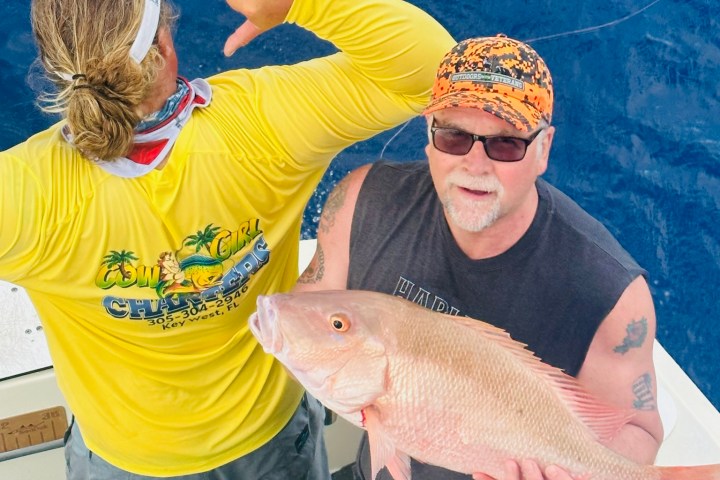 Angler with a freshly caught mutton snapper on a deep sea fishing charter in Key West, Florida