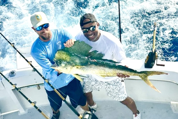 Angler holding a freshly caught mahi-mahi on a private fishing charter in Key West.