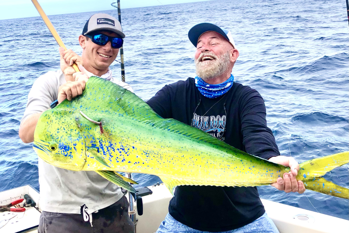 Happy angler holding a mahi mahi caught during an offshore fishing trip in Key West, Florida