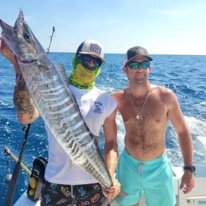 a man holding a fish in the water