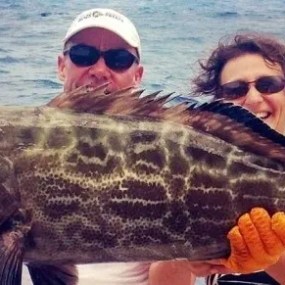 a man holding a fish in the water