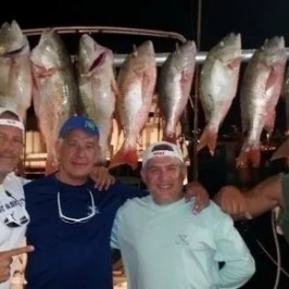 a group of people posing for a fish