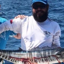 a man holding a fish on a boat