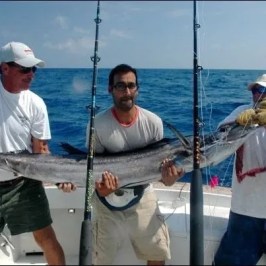 a man holding a fish in the water