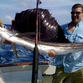 a man holding a fish on a boat