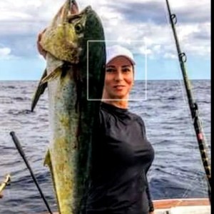 a person holding a fish on a boat
