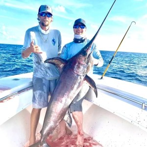 a man holding a fish on a boat