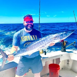 a man holding a fish in the water
