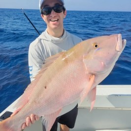a person holding a fish in the water