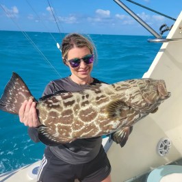 a person holding a fish in the water