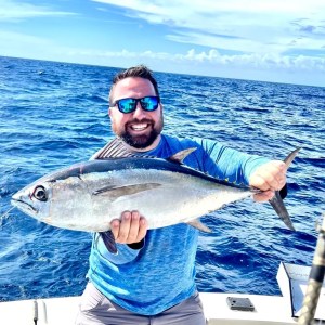 a man holding a fish in the water